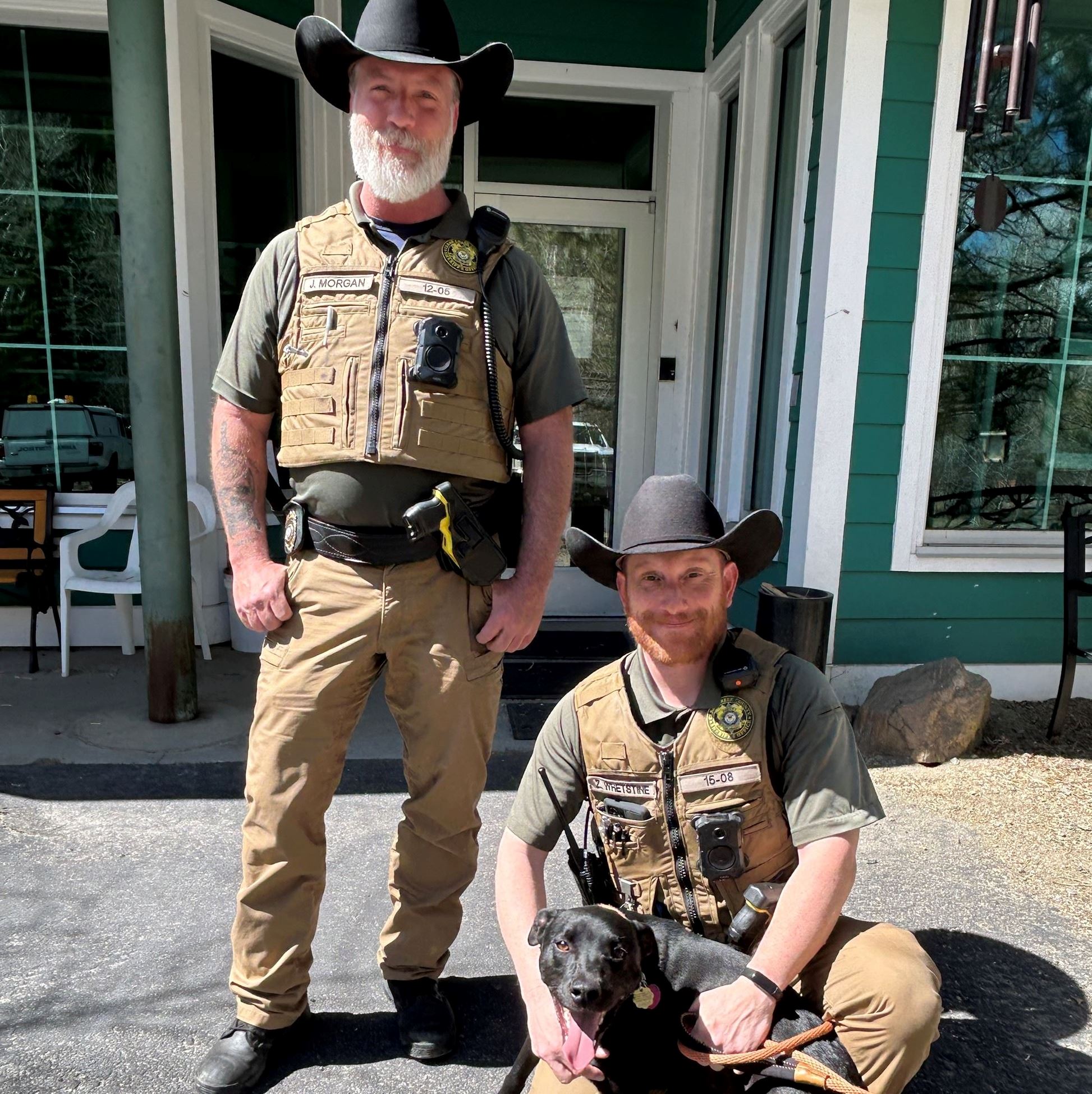 Community Enforcement Officers at Animal Shelter with a black dog